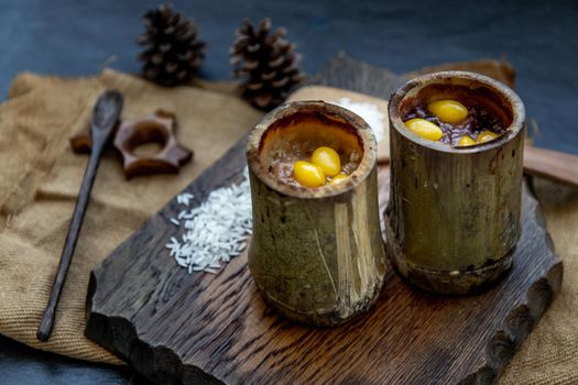 Sticky Rice Cooked with Coconut milk (Khao lam) or Glutinous rice roasted in bamboo joints on wooden, Thai dessert concept, Oblique view from the top.