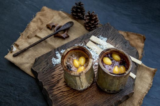 Sticky Rice Cooked with Coconut milk (Khao lam) or Glutinous rice roasted in bamboo joints on wooden, Thai dessert concept, Oblique view from the top.
