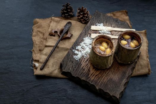 Sticky Rice Cooked with Coconut milk (Khao lam) or Glutinous rice roasted in bamboo joints on wooden, Thai dessert concept, Oblique view from the top.