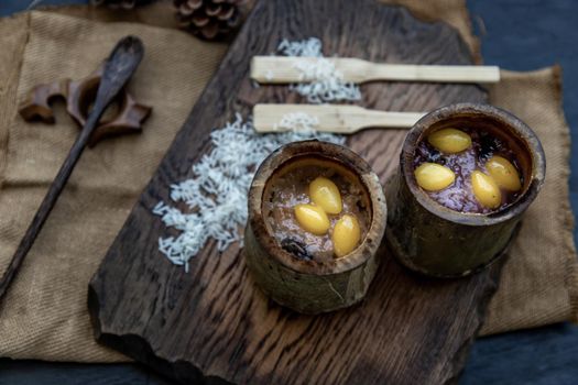 Sticky Rice Cooked with Coconut milk (Khao lam) or Glutinous rice roasted in bamboo joints on wooden, Thai dessert concept, Oblique view from the top.