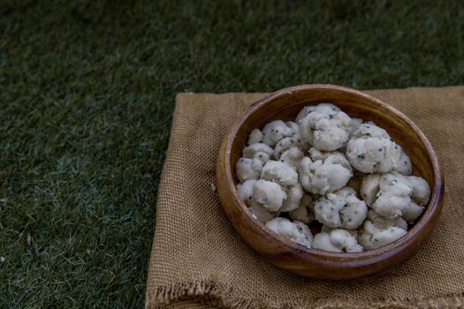Thai Shortbread Cookies (Thai Dessert), Kanom Kleeb Lum Duen on burlap fabric background, Oblique view from the top, Selective focus.
