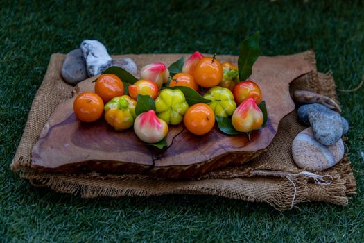 Kanom Look Choup : An old traditional thai dessert made from green been, coconut milk, sugar and jelly, Deletable imitation fruits made from green been, coconut milk, sugar and jelly in fruit shape on wooden, It is a unique dessert of Thailand, Oblique view from the top.