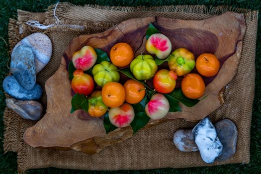 Kanom Look Choup : An old traditional thai dessert made from green been, coconut milk, sugar and jelly, Deletable imitation fruits made from green been, coconut milk, sugar and jelly in fruit shape on wooden, It is a unique dessert of Thailand, view from above.