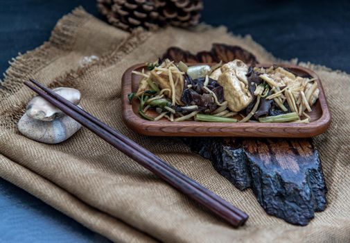 Thai food, Stir-fried tofu with ginger in wooden tray, Oblique view from the top.