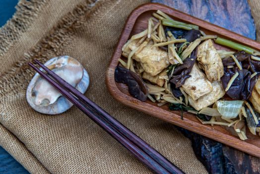 Thai food, Stir-fried tofu with ginger in wooden tray, view from above.