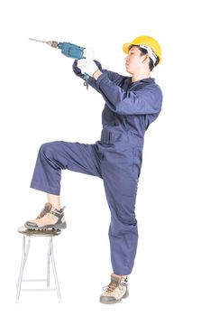 Young handyman in unifrom standing with his electric drill, Cutout isolated on white background with clipping path