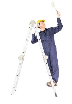 Young handyman in uniform standing on ladder while using paint roller, Cutout isolated on white background with clipping path