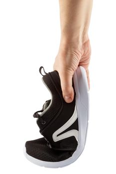 human hand bending lightweight black airmesh summer walking shoes isolated on white background.