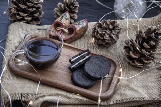 Cup of coffee with chocolate chip cookies on wooden tray. Concept for a tasty snack, Selective focus, Oblique view from the top.