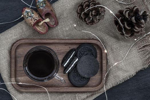 Cup of coffee with chocolate chip cookies on wooden tray. Concept for a tasty snack, Selective focus, Top view.