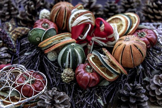 Close-up of Christmas decoration. Twigs christmas tree, brown natural pine cones and variety of fruits on burlap fabric background.