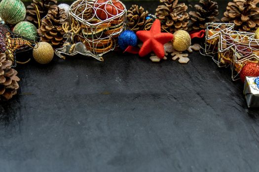 Wide arch shaped Christmas decoration border. Twigs christmas tree, brown natural pine cones and and Xmas deer with variety of fruits on dark background, Copy space.