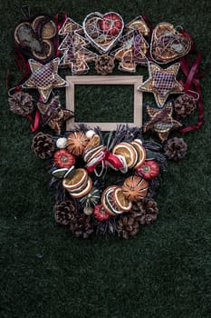 Christmas decoration, Brown natural pine cones and variety of fruits with Empty wooden frame for work about design element on lawn background, Copy Space.