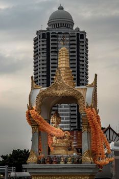Bangkok, Thailand - 13 Dec 2019 : Golden statue of Phra Phrom or four-faced Buddha With a high-rise modern buildings background. Four-faced Buddha regarded in Thai culture as deity of good fortune and protection. Selective focus.