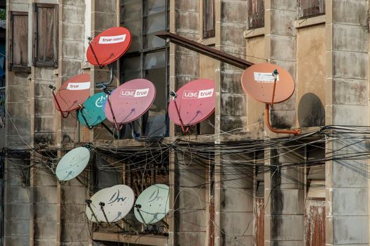 Bangkok, thailand - Feb 07, 2020 : Many satellite dishes mounted to the outside wall of a residential building. Selective focus.