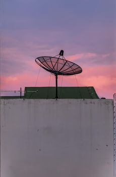 Black Satellite Dish Antenna Receiver Against on Blue Sky background  for Communication and Media Industry, Symbolizing Global Communications. Selective focus.