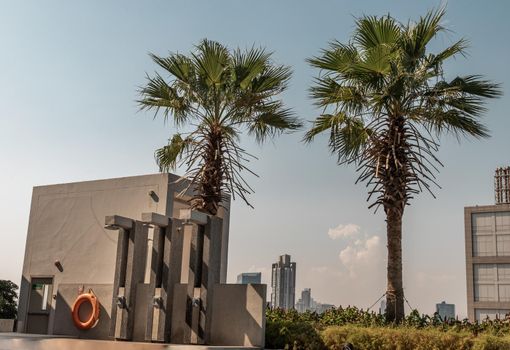Outdoor and Poolside shower with skyscrapers on background. Showering before entering the swimming pool.