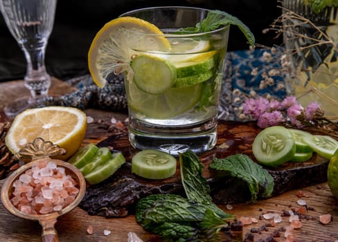 Cold water with lemon, kaffir lime, cucumber and mint leave on wooden background. Summer time, Healthy drink, vegetable juice, healthy food concept, Selective Focus.