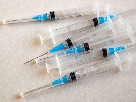 Disposable medical syringes are on table.