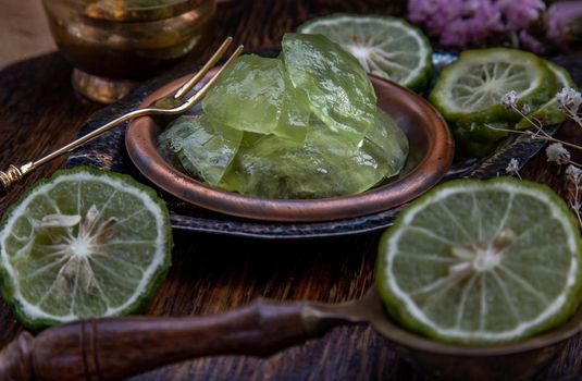 Traditional Thai dessert call candied kaffir lime on wooden background. Summer time, Selective Focus.