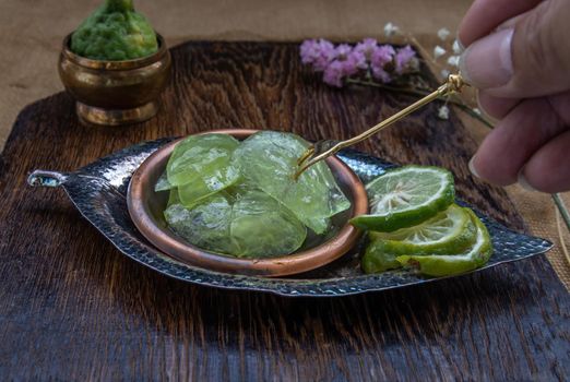 Traditional Thai dessert call candied kaffir lime on wooden background. Summer time, Selective Focus.