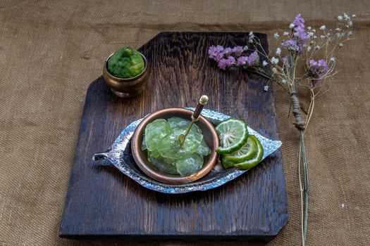 Traditional Thai dessert call candied kaffir lime on wooden background. Summer time, Selective Focus.