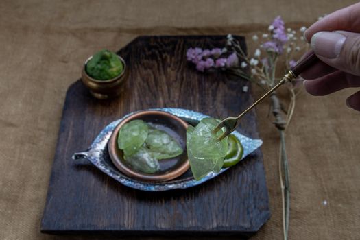 Traditional Thai dessert call candied kaffir lime on wooden background. Summer time, Selective Focus.