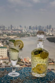 Cold water with lemon, kaffir lime, cucumber and mint leave on the table in front of sky background. Summer time, Healthy drink, vegetable juice, Selective Focus.