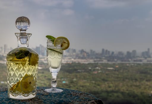 Cold water with lemon, kaffir lime, cucumber and mint leave on the table in front of sky background. Summer time, Healthy drink, vegetable juice, Selective Focus.