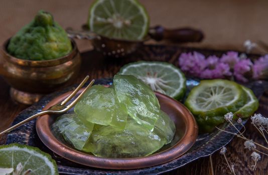 Traditional Thai dessert call candied kaffir lime on wooden background. Summer time, Selective Focus.