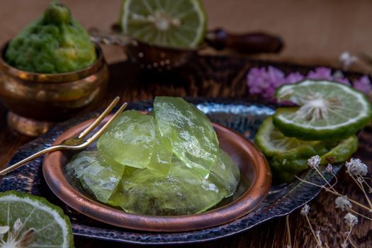 Traditional Thai dessert call candied kaffir lime on wooden background. Summer time, Selective Focus.