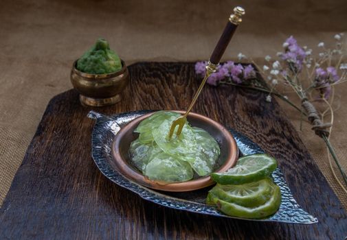 Traditional Thai dessert call candied kaffir lime on wooden background. Summer time, Selective Focus.