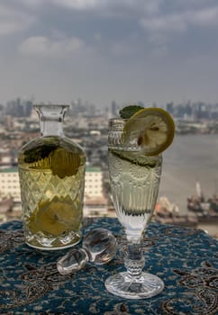Cold water with lemon, kaffir lime, cucumber and mint leave on the table in front of sky background. Summer time, Healthy drink, vegetable juice, Selective Focus.