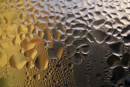 Water droplets or condensation on the outside of a cold windows in a close up full frame background texture