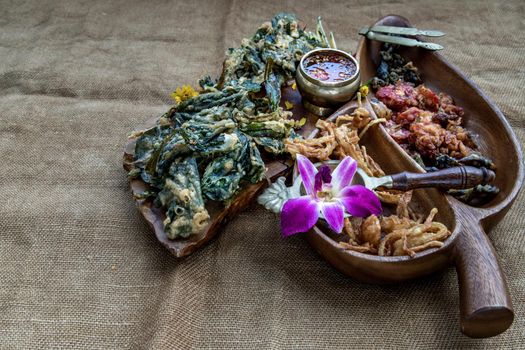 Crispy Flowers, Crispy Herbs and Crispy Vegetables served  with Sweet sauce in a Wooden tray, Oblique view from the top, copy space.