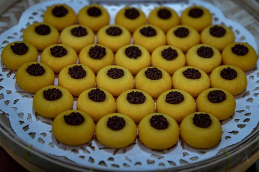 Traditional Thai Dessert (Kanom Thai) : Sanay Chan Made from minced coconut mixed with flour, sugar, egg yolk, rice flour and chan herb serving on a Bamboo basket hand made, Oblique view from the top.