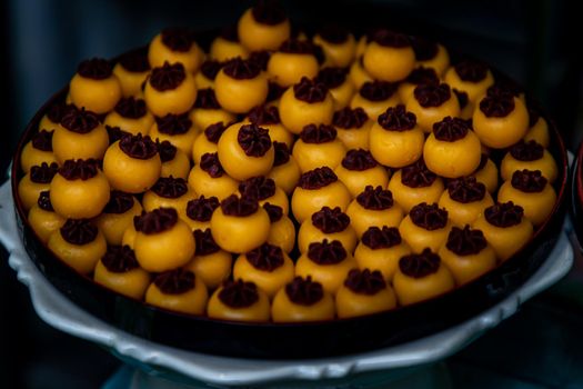 Traditional Thai Dessert (Kanom Thai) : Sanay Chan Made from minced coconut mixed with flour, sugar, egg yolk, rice flour and chan herb serving on a wooden background, Oblique view from the top.