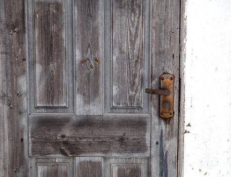 Wooden door with linings and rusty lock.