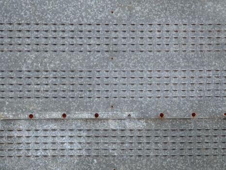 Grey metal sheets are fastened with screws.