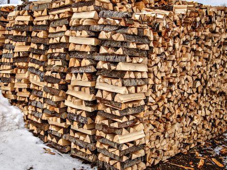 Firewood is split and stacked in even rows.
