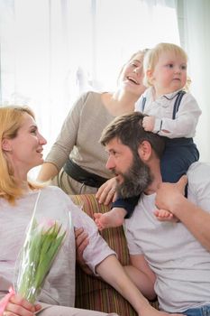 Dad with children congratulate mom on the holiday, mother's day. Have fun, laugh and give flowers