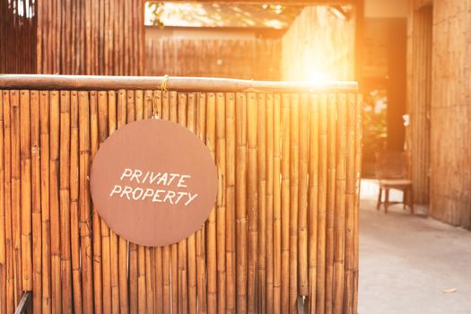 A Sign board of private property hang on door of business shop with wooden background