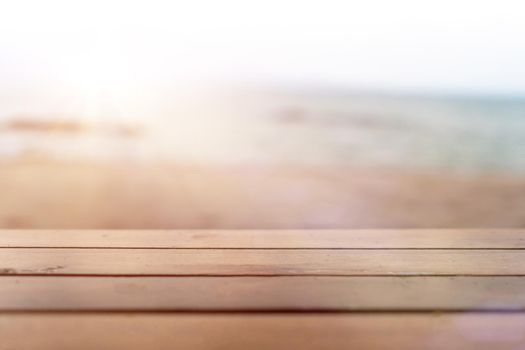 Selective focus of old wood table with blur beautiful beach background for display your product.