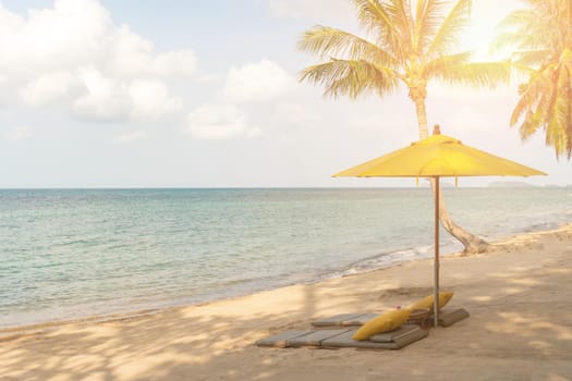 Umbrella and chair at tropical summer beach background with copy space blue sky.