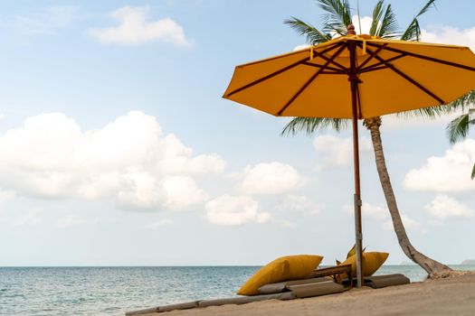 Umbrella and chair at tropical summer beach background with copy space blue sky.