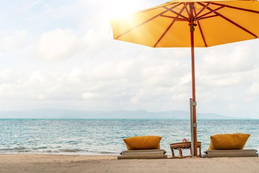 Umbrella and chair at tropical summer beach background with copy space blue sky.