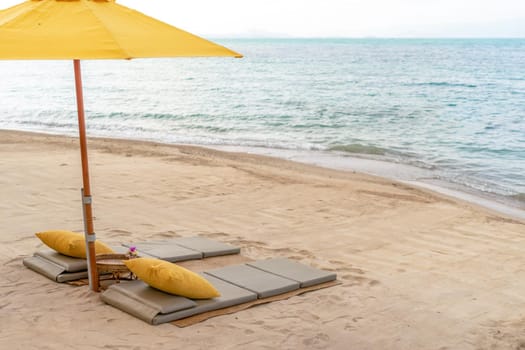 Umbrella and chair at tropical summer beach background with copy space blue sky.