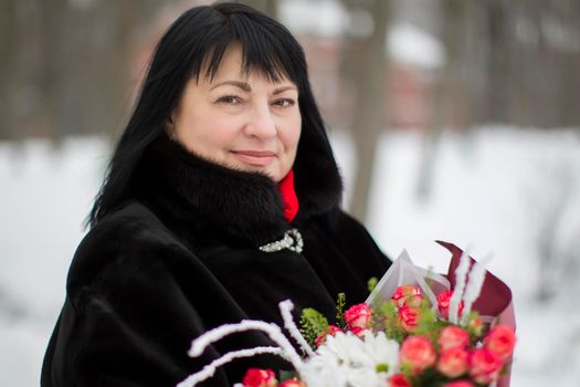 Beautiful elderly woman with a bouquet of flowers
