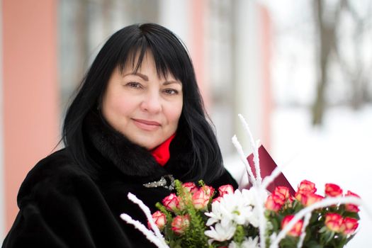 Beautiful elderly woman with a bouquet of flowers