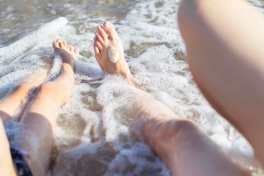 Feet of mom and baby in sea water